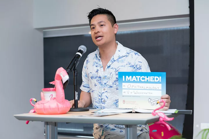 Jonathan Le holds an "I Matched!" sign