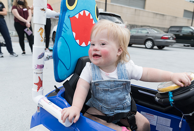 A child sitting in a toy car