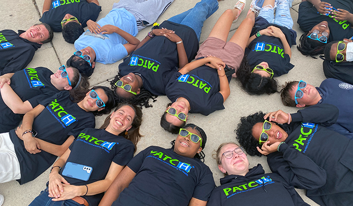 A group of teenagers with 'PATCH' t-shirts smiling together and having fun