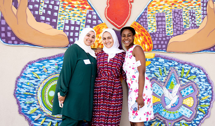 TRIUMPH students pose in front of a mosaic butterfly