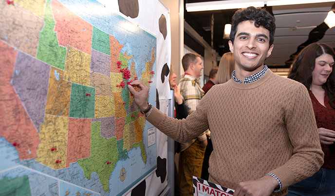An MD graduate places a pin on a map of the United States at Match Day 2024