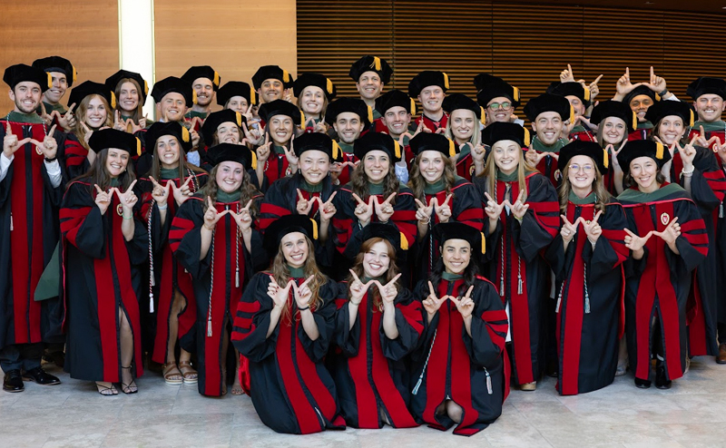 A large group of smiling Badgers in graduation caps and gowns
