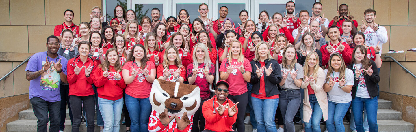 A large group of students smiling and repping UW–Madison