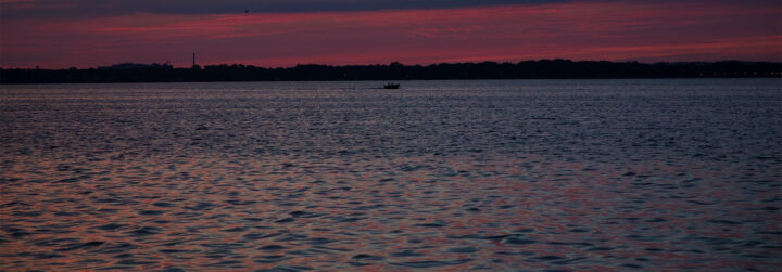 A sunset reflecting off a deep blue lake