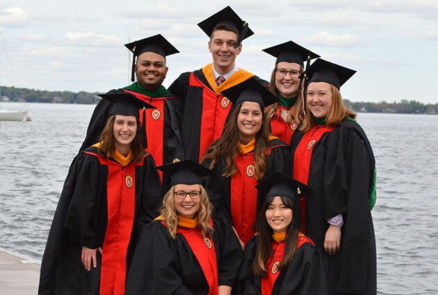 A group of graduates posing for a picture together in their graduation attire