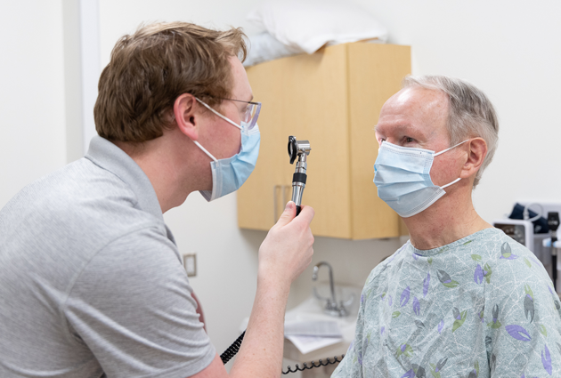 Student practices hands on learning by giving a patient an eye exam