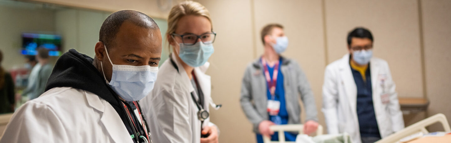 A group of doctors training together in a medical room