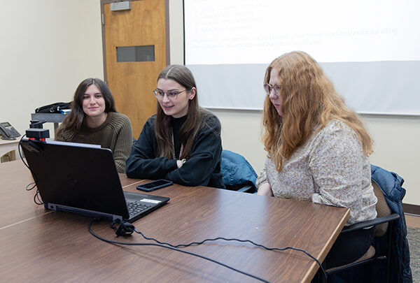 Students gathering around a computer