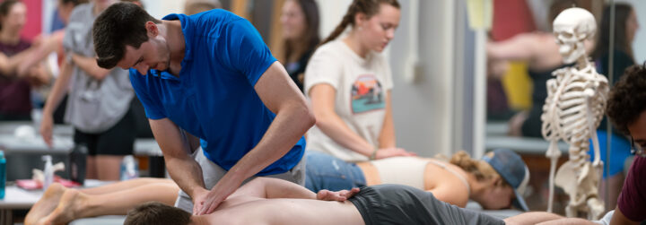 Students learn through simulating hands-on physical therapy practices with other students