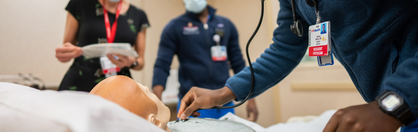 Student practices checking a patient's heart rate