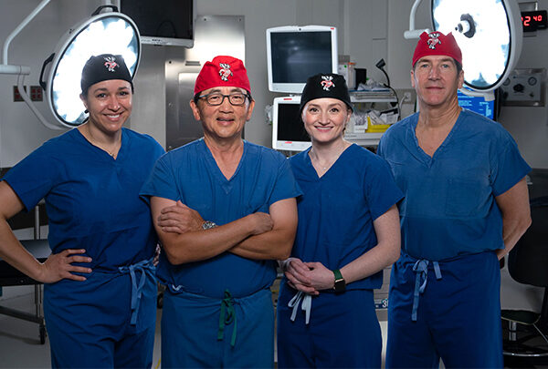 Four health care workers standing proudly in scrubs