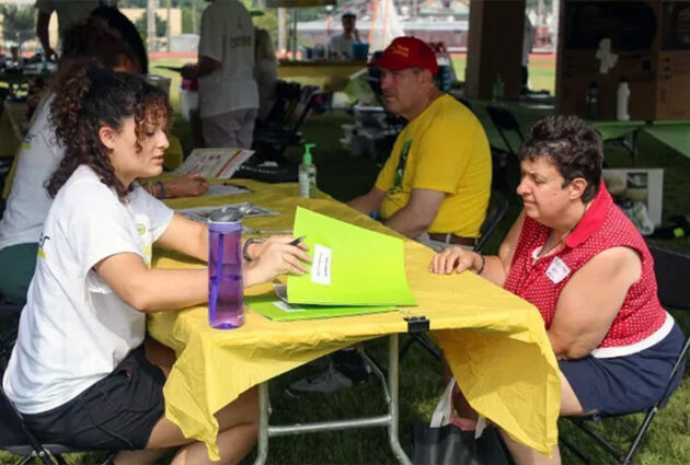 A student working with a community member at an event