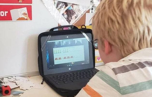 An elementary school student working on a laptop