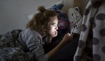 A teen girl captured by her cell phone screen