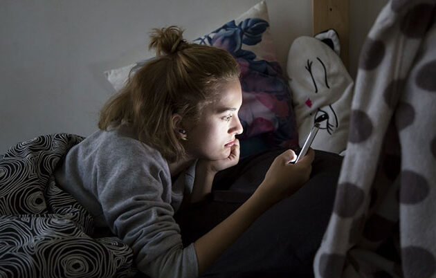 A teen girl captured by her cell phone screen