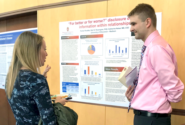 A student discussing their research poster