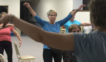 An older woman takes part in a group class