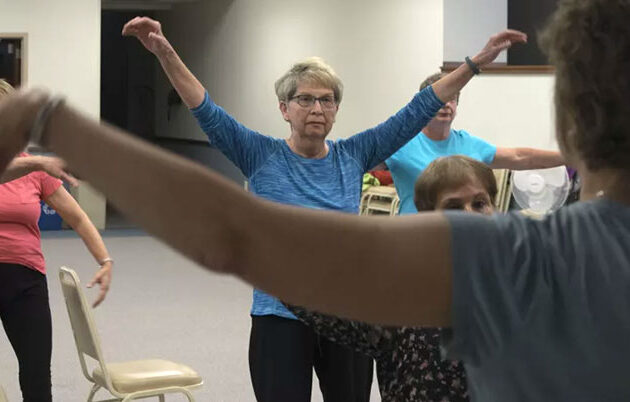 An older woman takes part in a group class