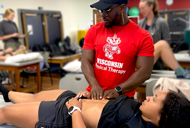 DPT student checks another student's stomach in lab