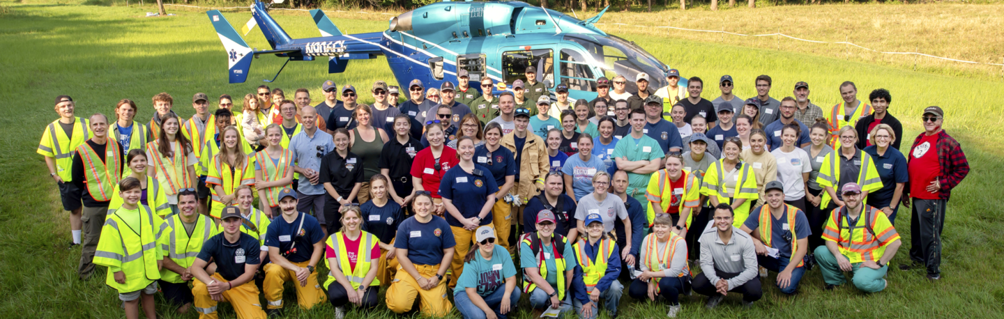 Group of Wisconsin Academy for Rural Medicine students and instructors standing in front of a rescue helicopter