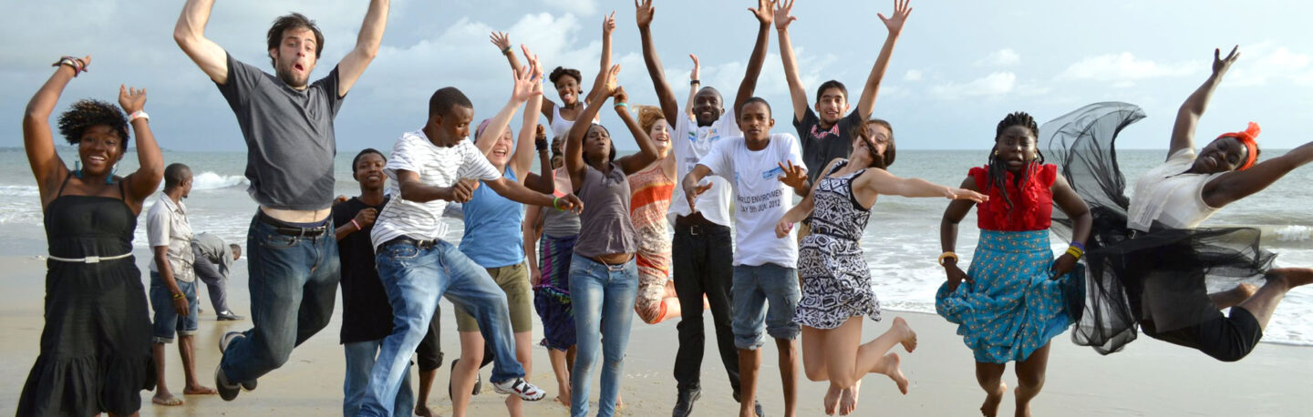 young people jumping in the air on a beach