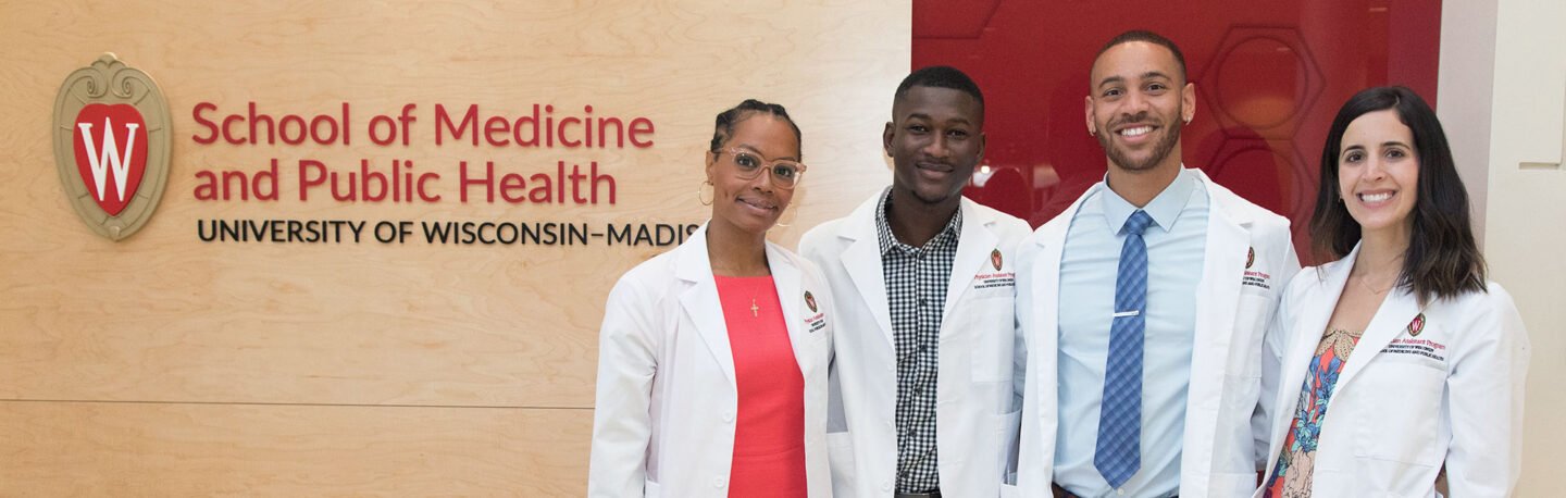 PA students standing in front of a UW School of Medicine and Public Health sign