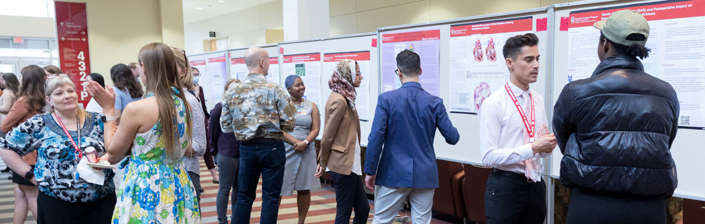 PA students talk with attendees at the capstone symposium