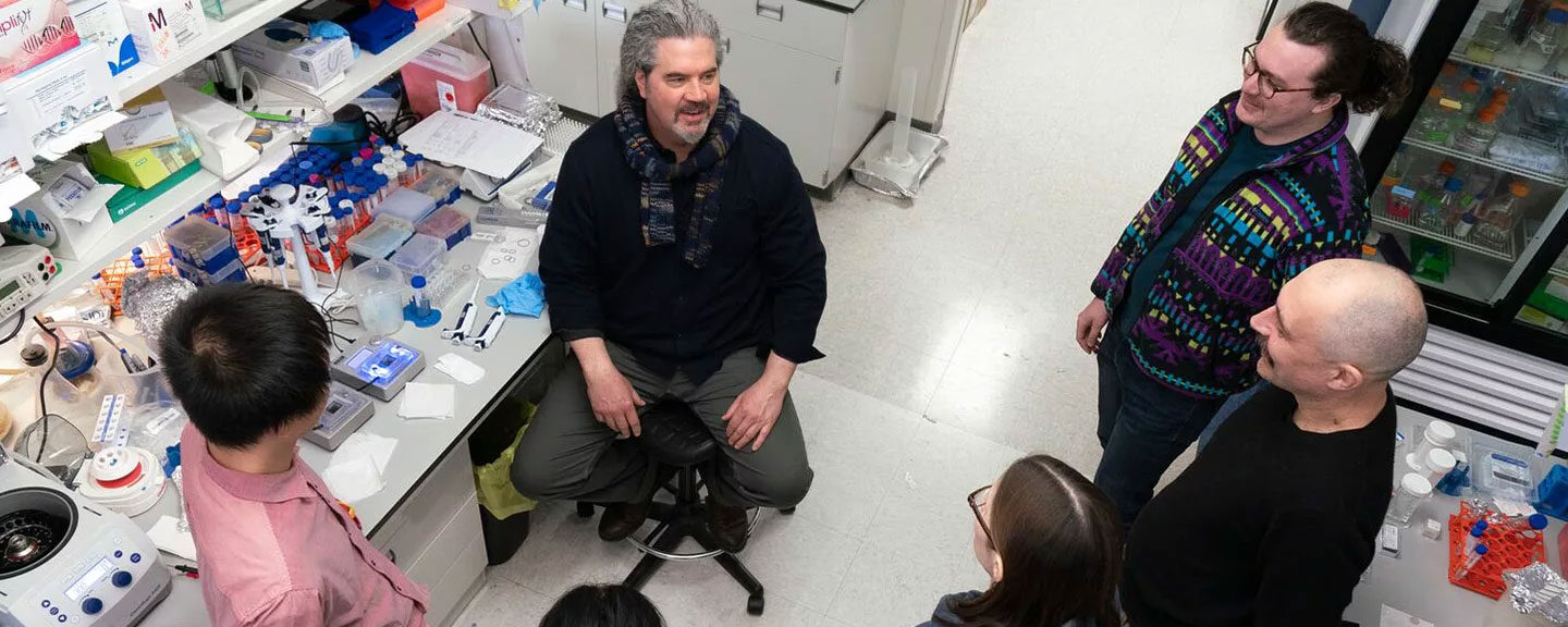 Ed Chapman talks with a group of people in his lab