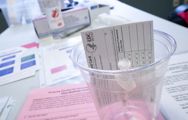 A COVID-19 vaccine card and syringe