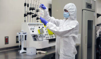 A researcher in PPE working in a lab