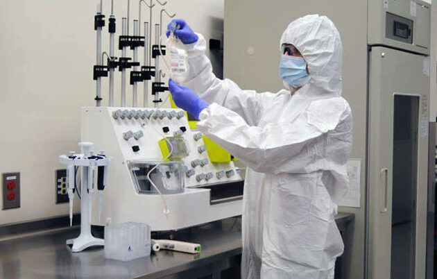 A researcher in PPE working in a lab