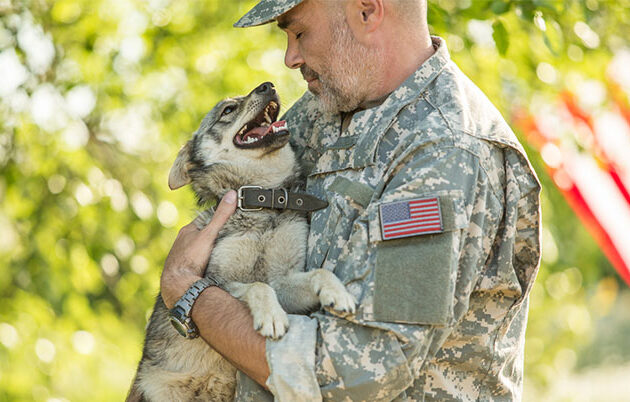 A military veteran holding a happy puppy