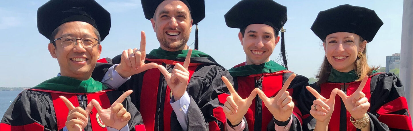 MSTP graduates smiling in front of a lake