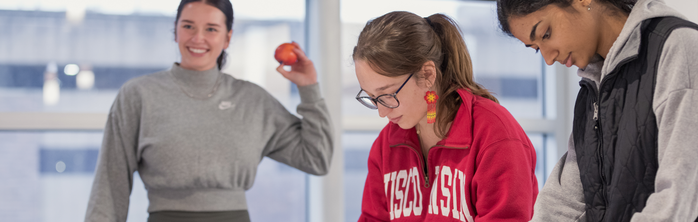 students gather around a table with apples on it