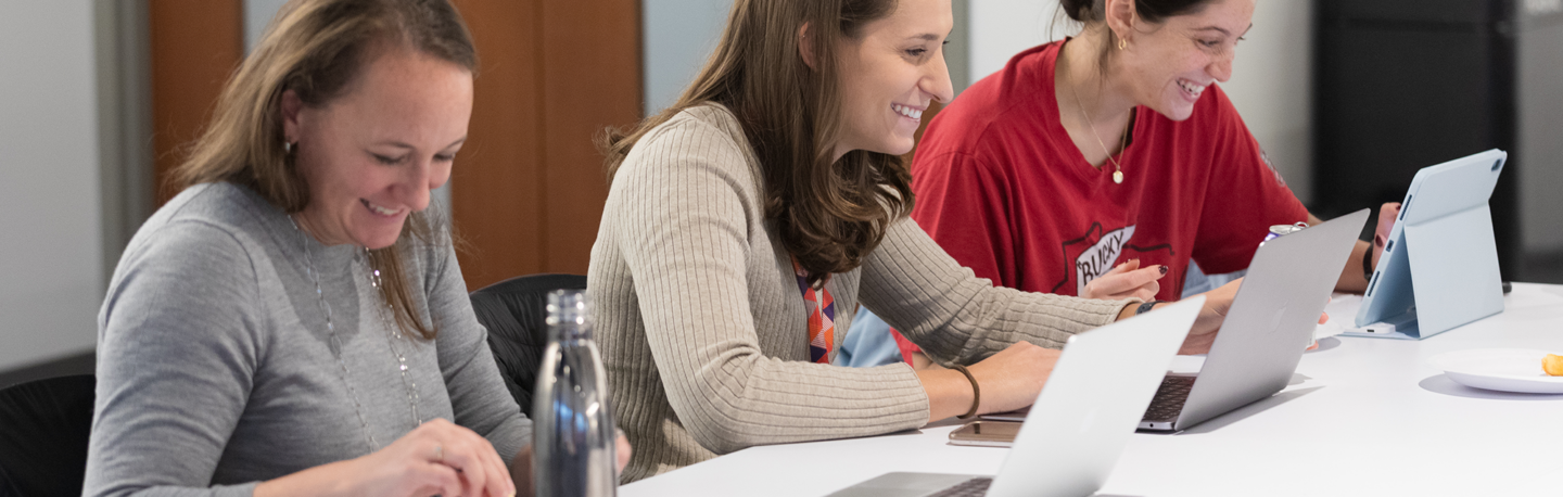 students with laptops smiling