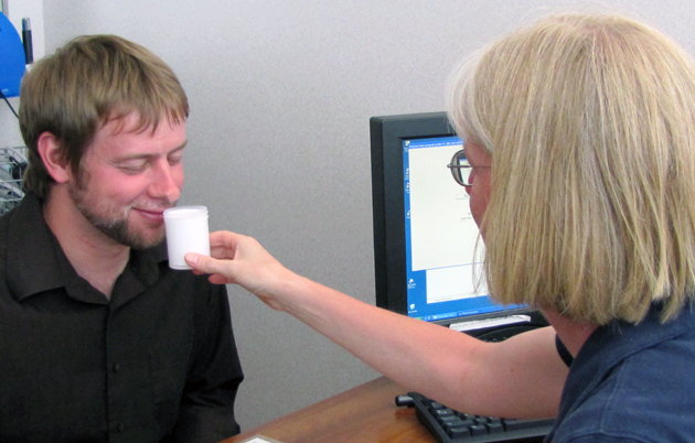 A study participant smells a container filled with a white substance