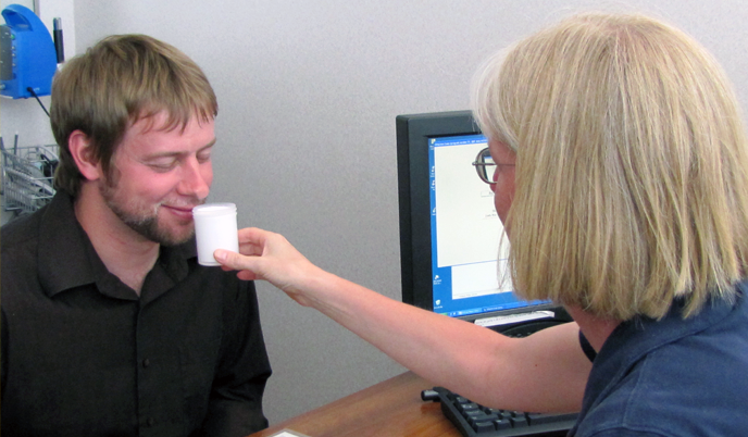 A study participant smells a container filled with a white substance