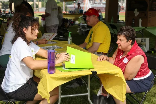 A student working with a community member at an event