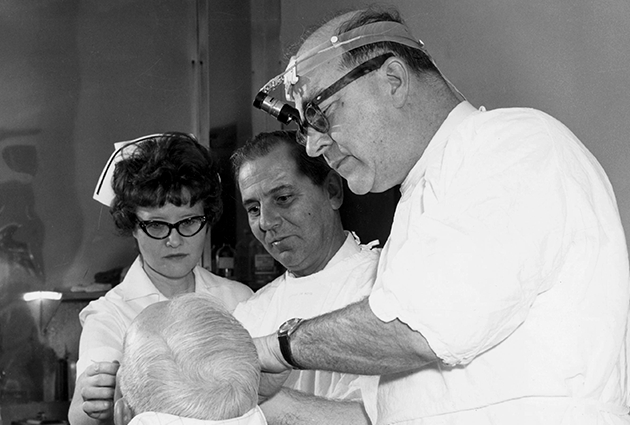 Frederic E. Mohs with clinic staff, evaluates a patient