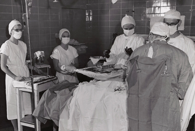 Doctors operating on a patient, with assistance from nurses
