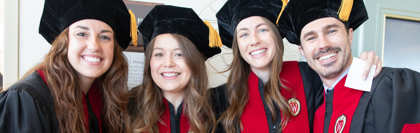 Smiling group of 2024 UW School of Medicine and Public Health MD graduates in graduation robes and caps