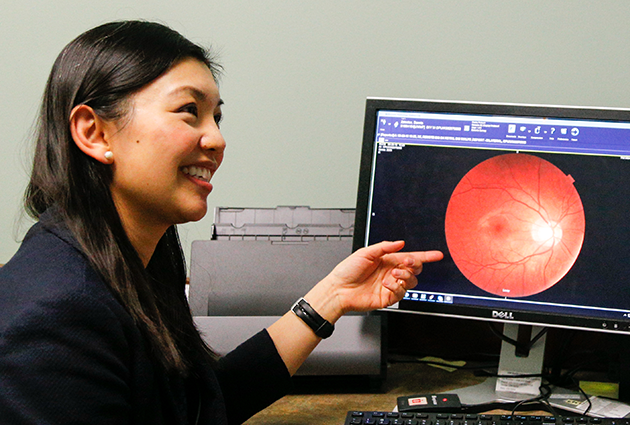 Dr. Yao Liu points to a retinal scan on a computer monitor