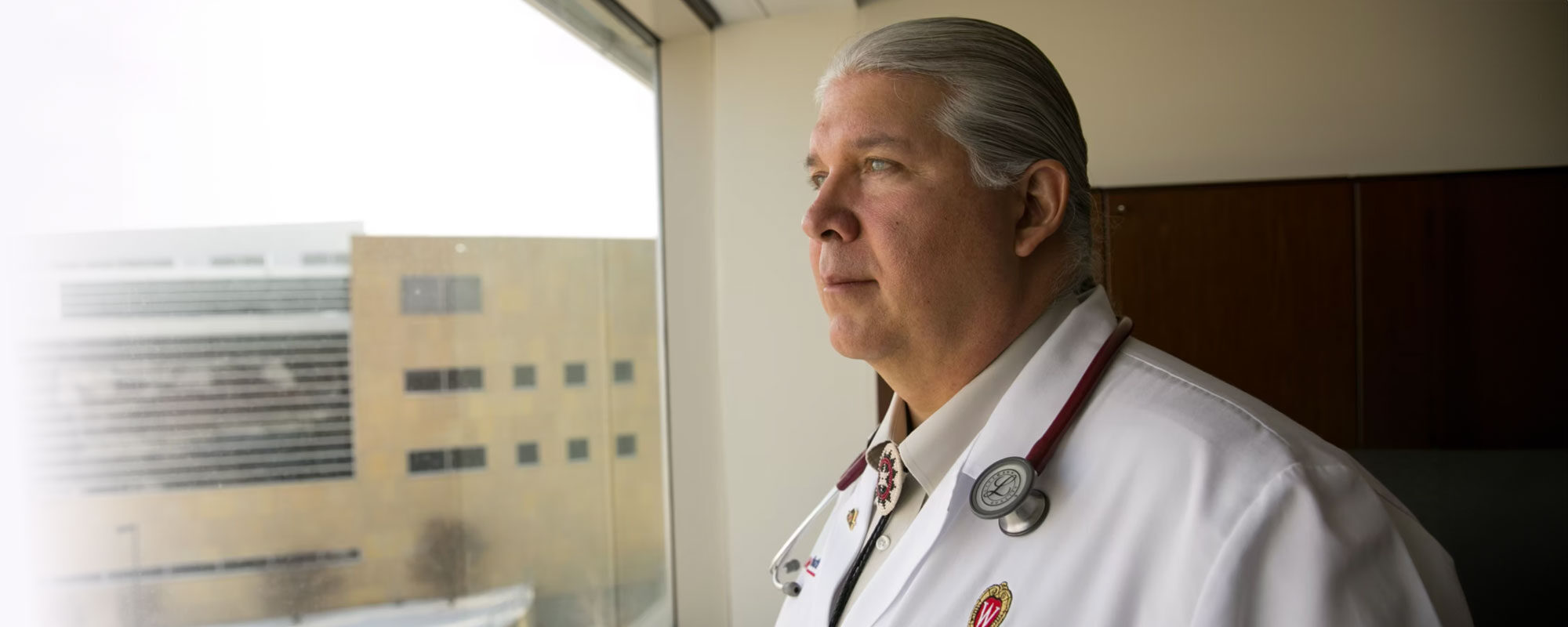 Bret Benally Thompson looks out a window, photo credit: We Are Healers