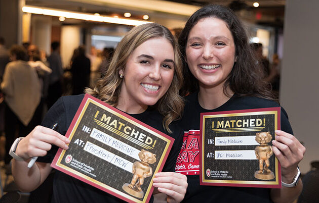 Smiling students hold "I Matched" signs