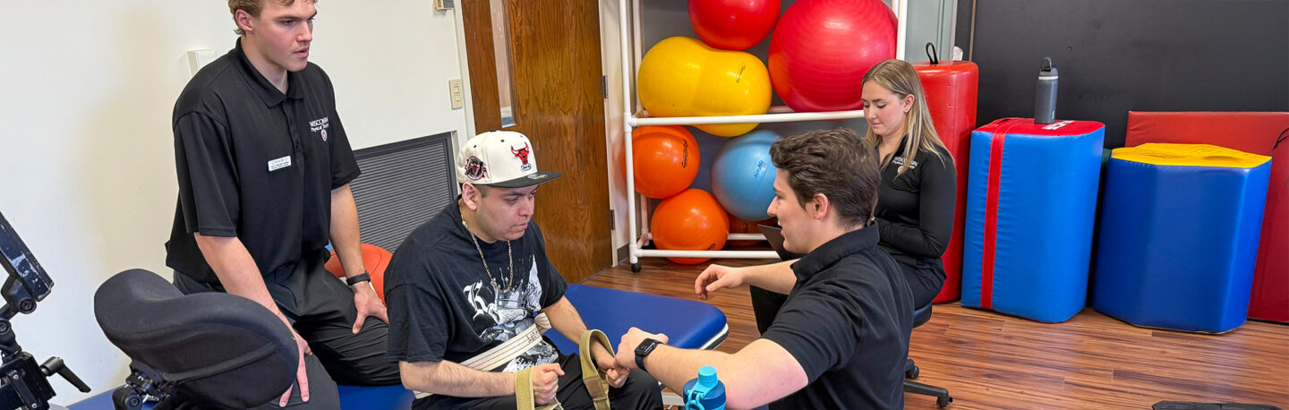 Physical therapy students work with a patient