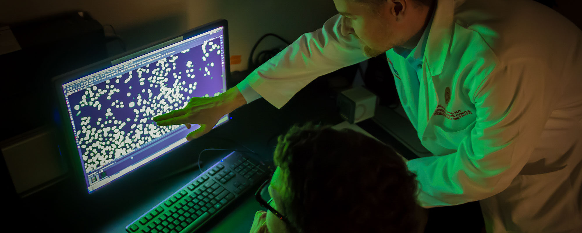 Joshua Lang reviews images from a prostate cancer cell line experiment (photo by Clint Thayer)