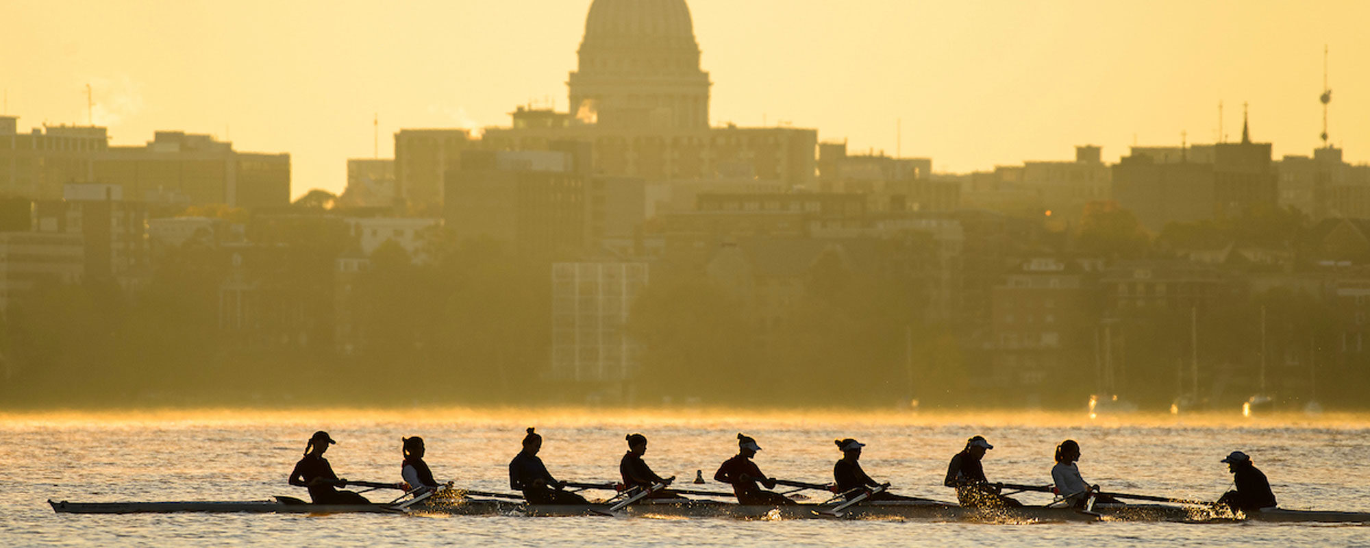 UW women's rowing team on Lake Mendota with silhouette of the State Capitol (Photo by Jeff Miller/UW-Madison)