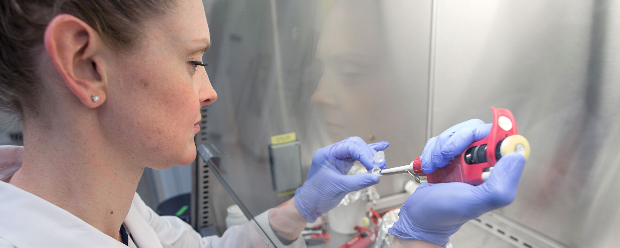 Evie Carchman uses a pipette inside a fume hood