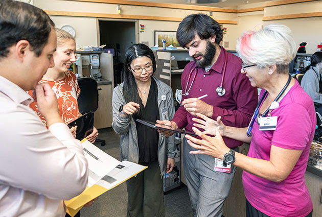 Students and physicians collaborate in a circle