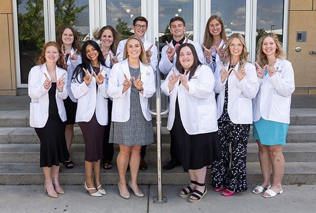 A group of students wearing white medical coats